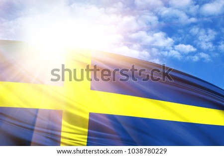 flag of Sweden against the blue sky with sun rays