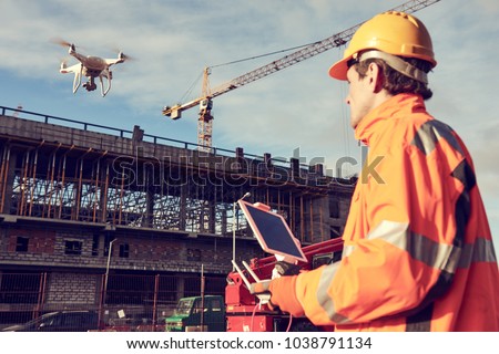 Drone operated by construction worker on building site Royalty-Free Stock Photo #1038791134