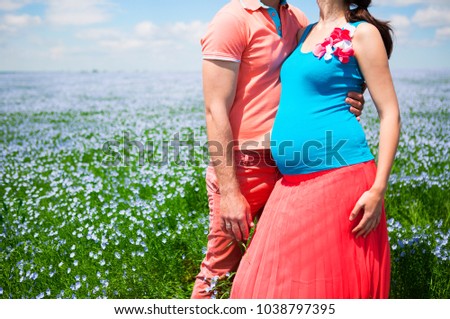 Young beautiful pregnant couple in linen field. Close up