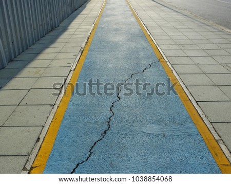 Bicycle path on footpath with large crack in city