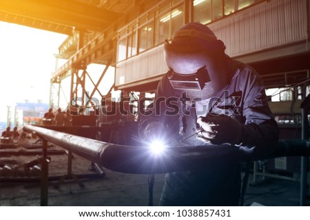 worker welder Tic welding in piping shop in shipyard with office background and dark tone Royalty-Free Stock Photo #1038857431