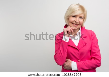 A picture of fashionable and stylish grandma wearing bright coat. She is nt afraid of bright colors. She likes to take experiments. Isolated on white background.