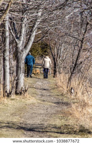 two people and a dog walking down a scenic path