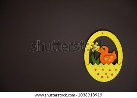 Happy easter egg with orange duck and flower  on brown backround. top view
