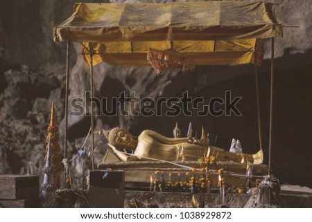 old reclining golden buddha statue in the cave