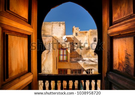 Balcony view of Arab building and window. Rustic balcony doors and view in the Medina of Fes, Morocco. Famous example of Moroccan architecture and a popular tourist sight