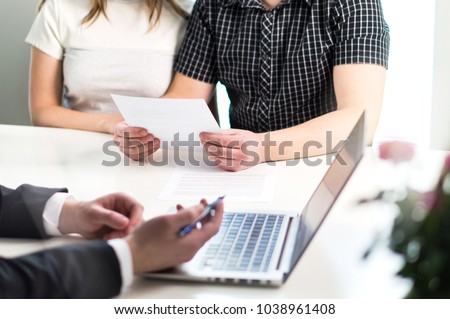 People having meeting about mortgage, bank loan, buying house, insurance or apartment rent. Woman, man and lawyer preparing prenupitial agreement in office. Person reading real estate paper contract. Royalty-Free Stock Photo #1038961408
