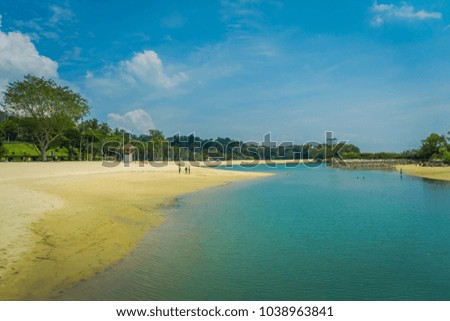 Beautiful outdoor view of unidentified people enjoying the yellow sand and tropical beach in sentosa and swimming in a natural pool in Singapore