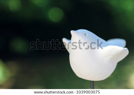 White ceramic flying bird on blurred background, soft and selective focus. Copy space.