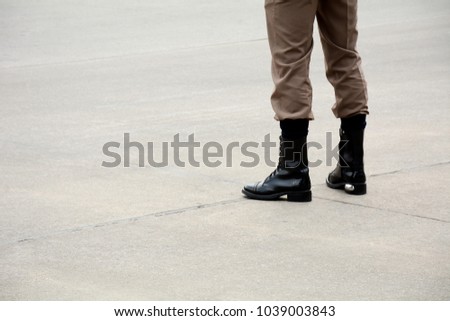 boots of soldier standing on the road in urban