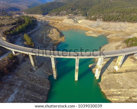 Aerial drone view of bridge over turquoise waters in Llosa del Cavall Lake, near Barcelona, Catalonia, Europe. Dry lake for climate change warming. Beautiful, bridge adventure and travel