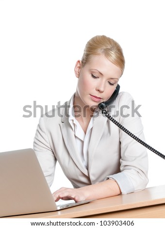 Young business woman sitting at a desk and holding phone handset, isolated