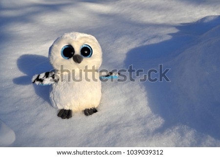 Cute owl toy on the snow outdoor.