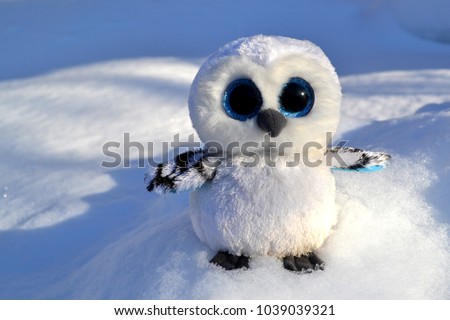 Cute owl toy on the snow outdoor.