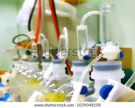 Selective focus of the arrangement of many IV infusion sets on top of saline solution bottoms for kidney dialysis machine in hospital 
