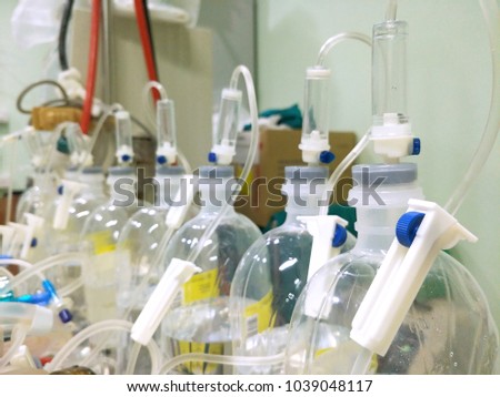 The arrangement of saline solution bottoms and IV infusion sets for kidney machine in hospital on medical and health care concept, selective focus 