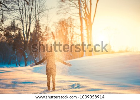 Woman throwing snow in winter snowy nature