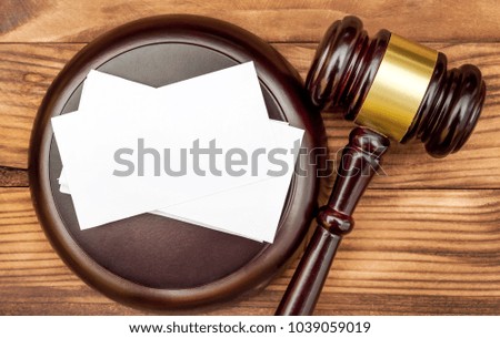 Blank business card with judge's gavel on the table. Top view.