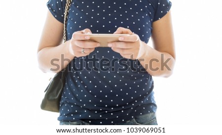 Isolated closeup image of young woman in jeans using mobile phone