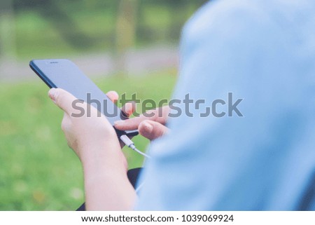 Young business female using smart phone while she is relaxing in Park in the fresh air