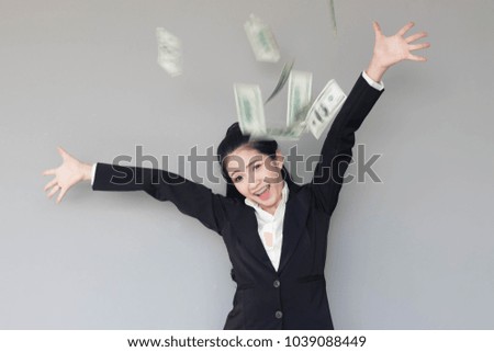 Happy young business woman enjoying the rain of money.