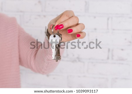 Girl holding a bunch of keys on white wall background