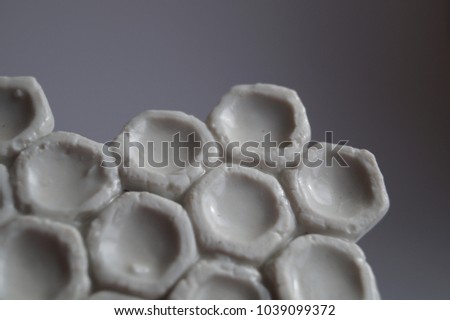 Close-up of white porcelain honeycomb. Ceramic modular element. Texture honeycomb. White background.