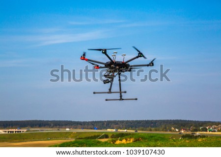 drone with camera flying over beautiful scenery and blue sky controlled by wireless remote control, digital hum, aeronautics
