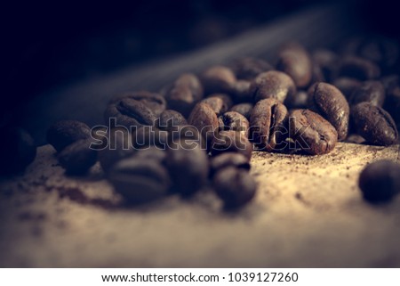 Grains of coffee lie on ground coffee. Unusual photo low key.