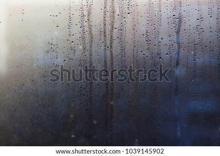 Rainy background with flowing down water drops on window glass