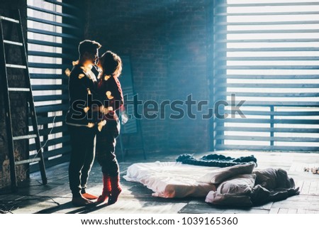 Silhouette of lovers standing near window and looking to each other. Magic light. 