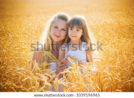 mother and daughter in a wheat field. selective focus.