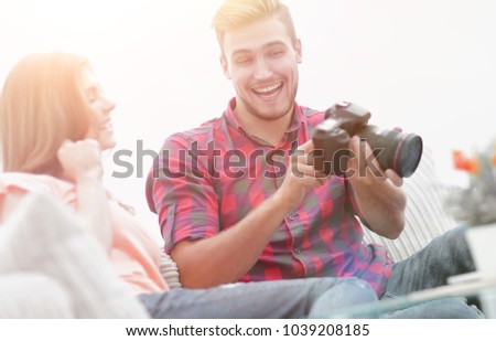young man shows a photo of his girlfriend sitting in the living 