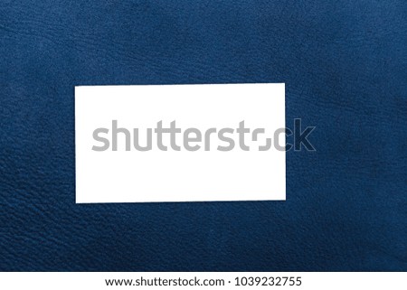 Close up of blue leather background or texture. white business card on brown leather lining