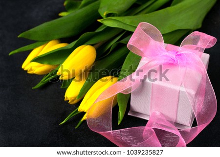 flowers and gift on black background