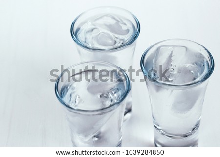 vodka shots with ice on a white background