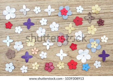 Colorful natural leather flowers on wood background.