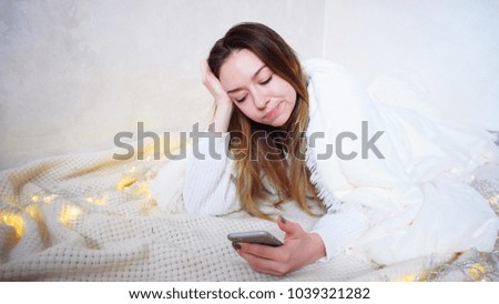 Charming, compassionate Young Woman read joyless news on mobile screen. girl with bad mood and without smile on face leads along touch screen of gadget. Woman European appearance with long blond hair