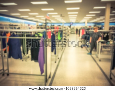 Blurred abstract inside a off-price department stores in America. Fashion boutique interior, clothes shop with bokeh light background. Customer shopping. Vintage tone
