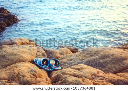 shoes on the rock with sea water background