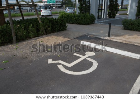Handicapped parking spot on asphalt - transportation infrastructure road markings and sign.