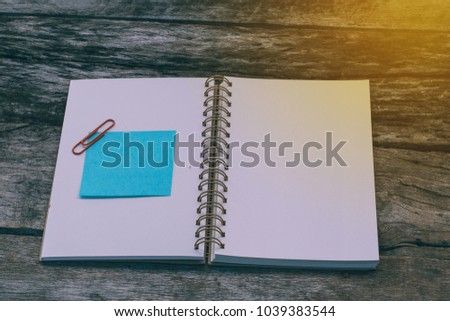 Empty paper sheet blue with blank notebook on wooden background home office desk. add text message. Memory day note story everyday. Home workspace concept.