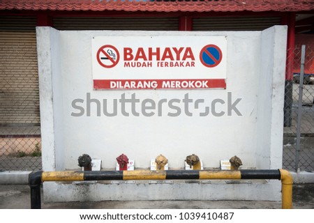 "Danger, Highly Flammable and No Smoking" Signboard with yellow and black fuel metal piping