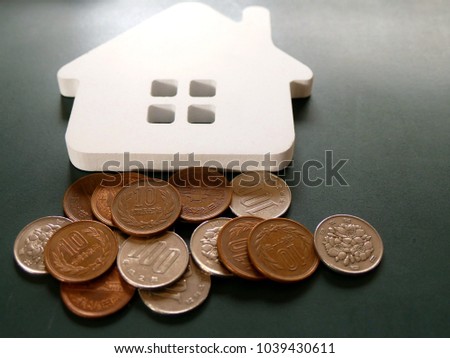 house model with the background of a lot of Japanese coins (yen). the concept of investment in property  or home loan concept 