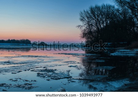 Frozen Ice Floes at sunset twilight in the Northern Germany River Elbe near Hamburg 