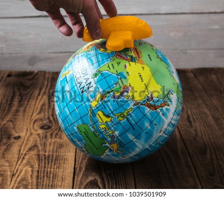toy airplane and the globe on wooden background