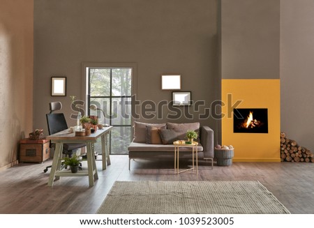 Decorative modern home office interior. Brown and yellow stone wall detail with fireplace.  Wooden working table and grey sofa with green armchair furniture. new style home office plan.