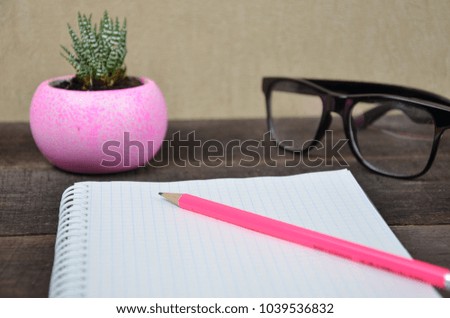 Notebook pencil glasses on the background of the flower