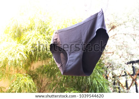 Black underwear is hanging on the cloth rack around with tree, woman underwear on cloth rack.