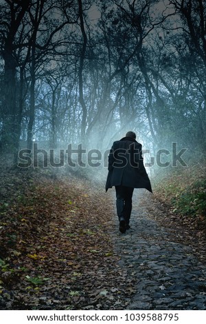 The man is walking along the paving stones